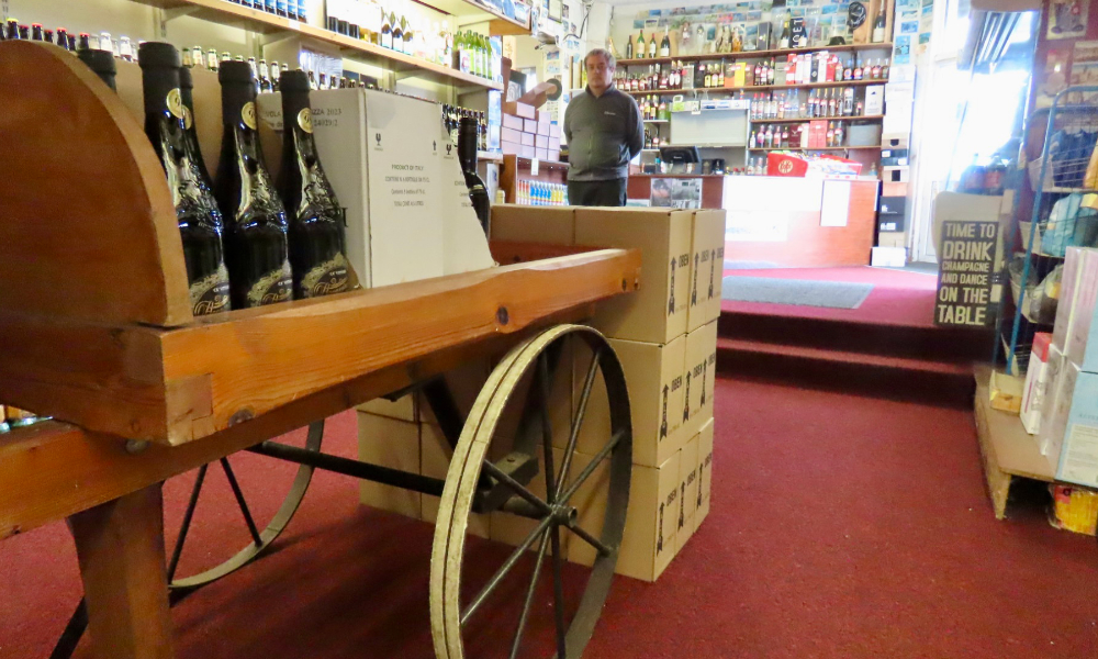 Wheeled cart holding wine bottles